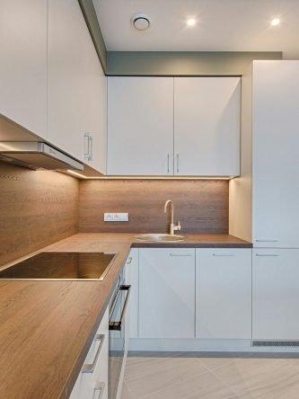 Modern kitchen interior with minimalistic design and wooden accents, captured with natural lighting.